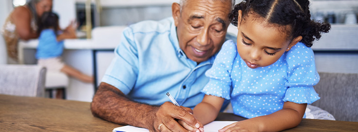 Grandfather helping his granddaughter with homework at home – Back to School Tips for Parents