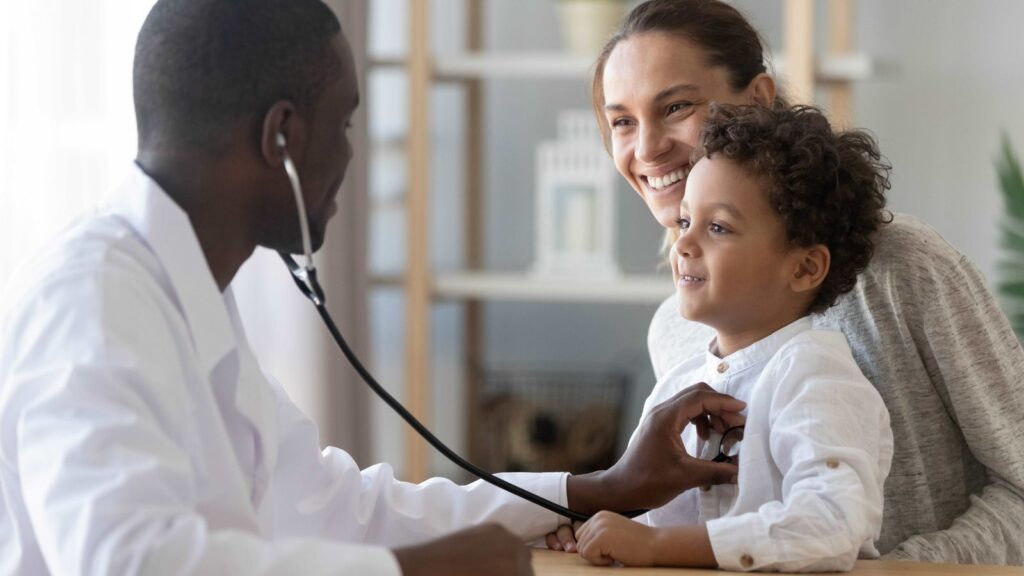 Child at doctor visit receiving care, representing flu and COVID-19 vaccination and pediatric health